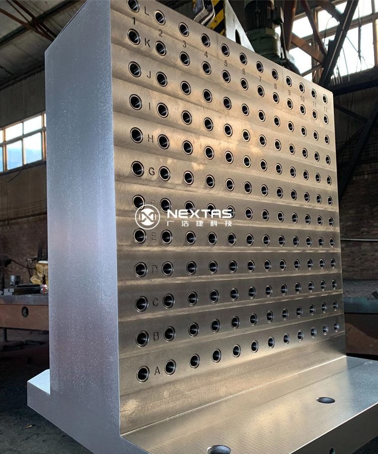 Columna de utillaje cuadrada con patrón denso de agujeros de precisión en el taller